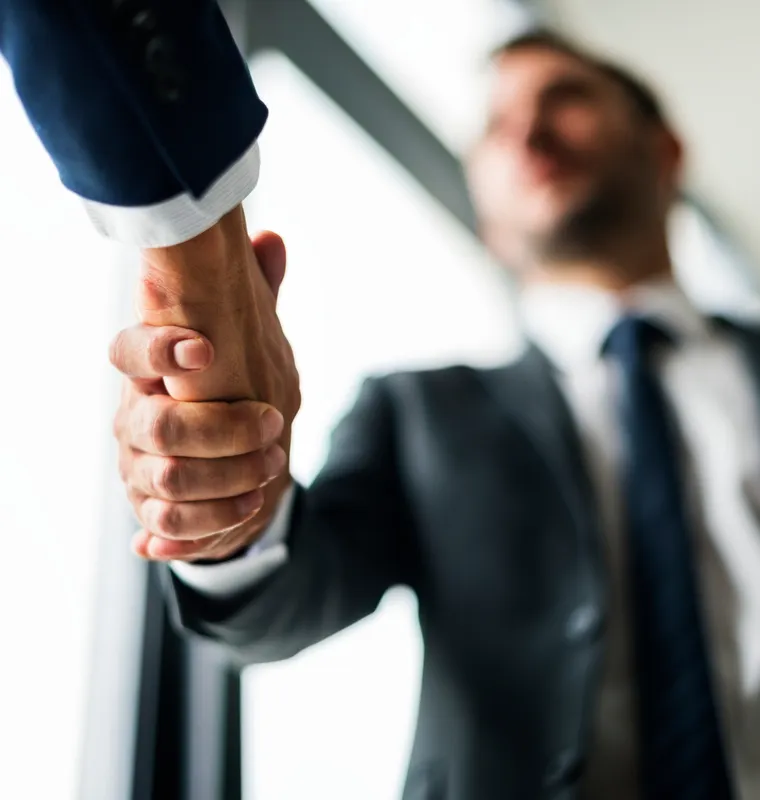 Apretón de manos entre dos profesionales que cierran un acuerdo de colaboración